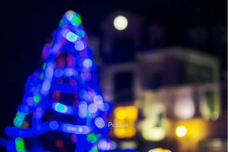 abstract blurry image of a blue Christmas tree in the old city center