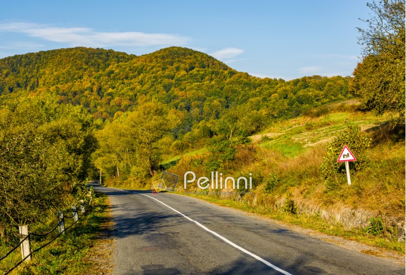 asphalt road with limitation sign in mountainous countryside. beautiful early autumn morning scenery
