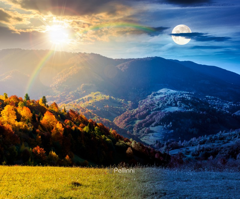 autumn equinox in mountain landscape. day and night time change concept. beautiful view of trees in fall foliage on the hillside with sun and moon at twilight. alps of countryside under dramatic sky