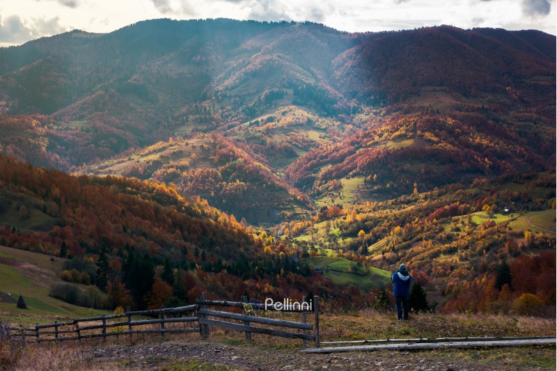 undefined person on the edge of a hill looking in to the distant rural valley. beautiful nature scenery in autumn