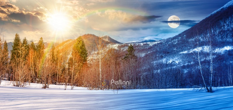 beautiful panorama of mountains in winter. day and night time change concept. leafless birch trees on snow covered meadow with sun and moon. landscape in cold season. equality and shift template