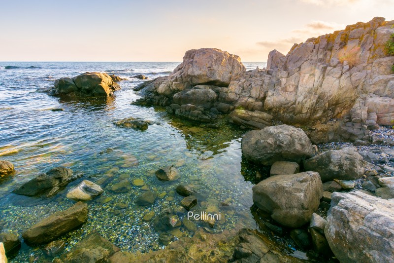 beautiful sunrise at the black sea. outdoor adventure. rocky coast and clouds on the blue sky in morning light. summer vacations and weather change concept. natural environment