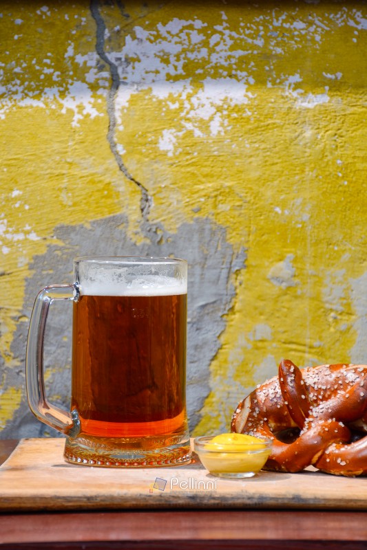 beer pretzel and mustard on a wooden table. rustic oktoberfest d beer pretzel and mustard on a wooden table. rustic oktoberfest drink and food background. grungy wall texture. vertical view