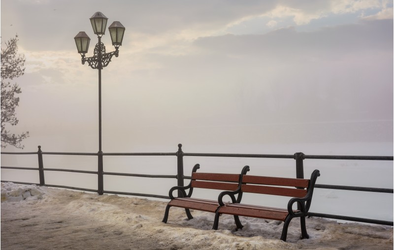 bench and lantern on foggy winter morning. location Nezalezhnosti embankment Uzhgorod, Ukraine