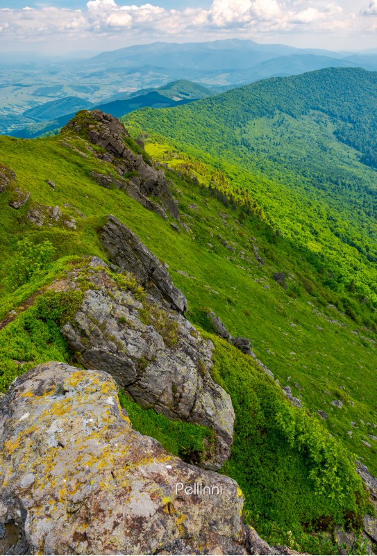 boulders along the mountain ridge. location Pikui mountain. Borzhava mountain ridge in the far distance on the horizon. Beautiful summer landscape of Carpathian mountains