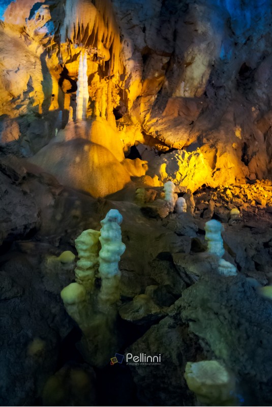 cave with colorful textured walls and stalactites and stalagmite