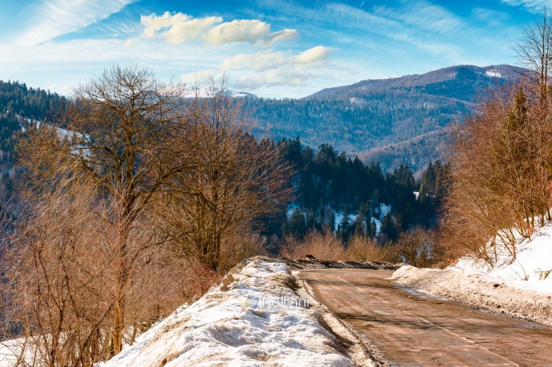country road winding through winter landscape under blue sky. great bereznyi district of carpathian mountains on a sunny day. scenic view of uzhanian pass. travel background with snow covered slopes