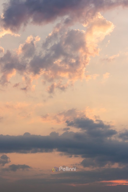 cumulus clouds on the sky blown by the wind. sundown stormy. cloudy weather meteorology background in orange glow. evening mood