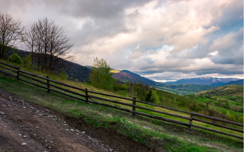 fence on a hillside of mountainous countryside. lovely rural scenery in springtime