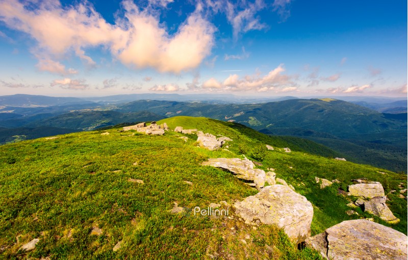 fresh summer forenoon scenery in mountains. beautiful with boulders on the grassy hill under the blue sky with some clouds.
