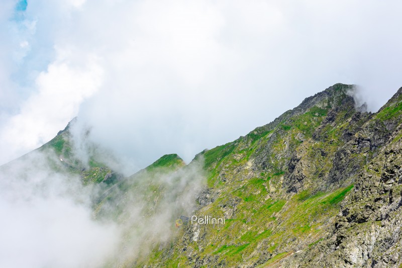 green mountain landscape. photography of carpathian mountain range of romania in summer. atmospheric travel background with realistic cloud scenery around vanatarea peak on a sunny weather