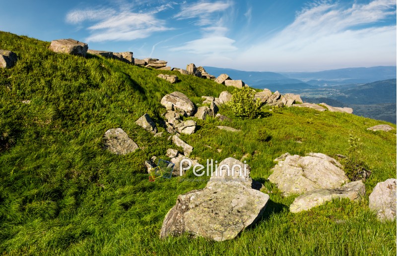 huge boulders on a grassy slope in mountains. lovely mountain landscape with sky full of beautiful clouds
