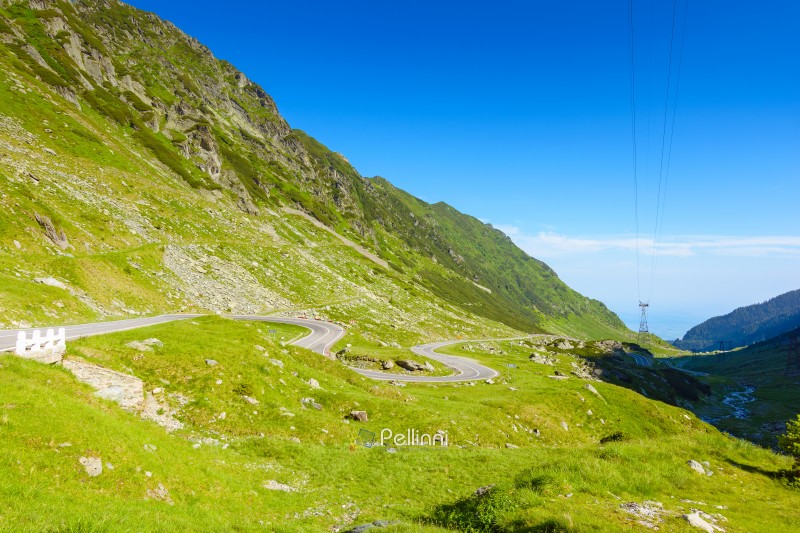 landscape with transfagarasan road in summer. travel romania. scenic view of valley with steep rocky hills and water stream on a sunny morning. alpine scenery of transylvania