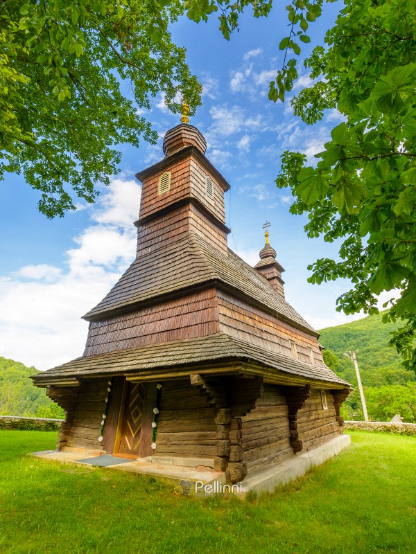 likitsary, transcarpathia, ukraine - 02 jul 2020: traditional wooden church architecture of europe. summer landscape in carpathian mountains. unique ruthenian religion heritage. front view