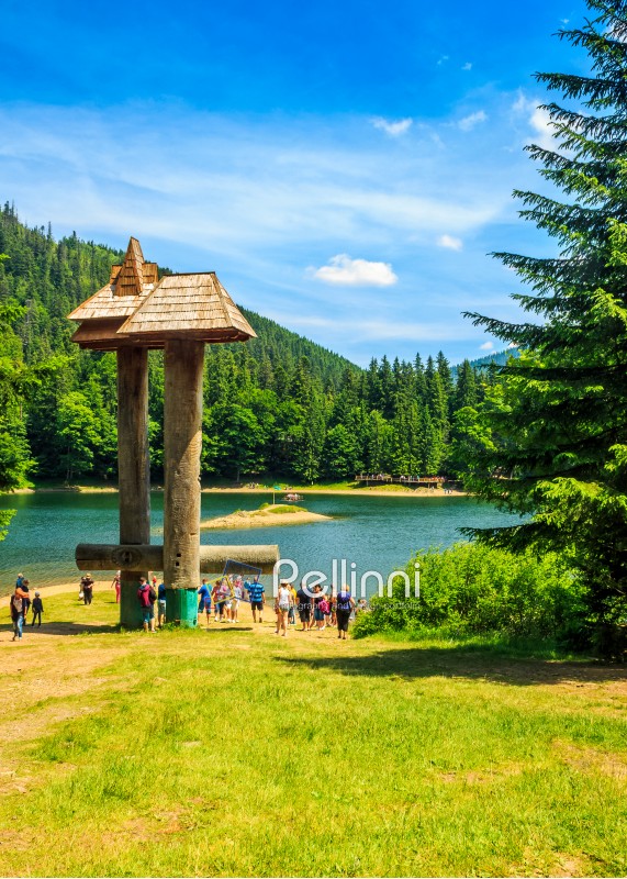 National Park Synevir, Ukraine - July 29, 2014:  tourist visiti mountain lake among the green fir forest in picturesque summer landscape. beautiful weather with blue sky and some clouds