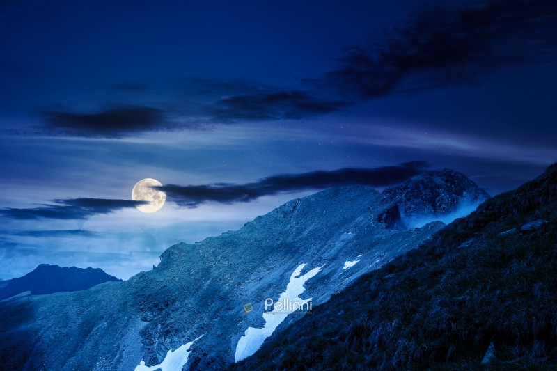 mountain landscape under cloudy sky at night. nature scenery travel background for hiking in summer vacation season in full moon light. scenic view of ridge with steep rocky slopes