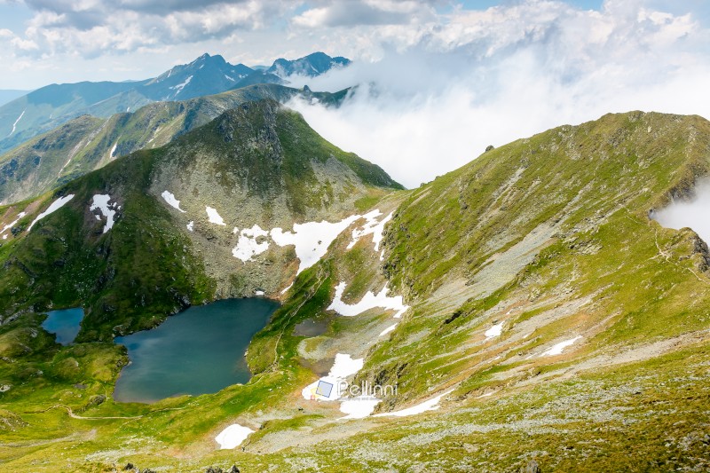 mountain landscape with alpine lake in summer. beautiful pond ne mountain landscape with alpine lake in summer. beautiful pond near popular hiking trail through transylvania alps of fagaras massif. postcard from romania on a sunny day. popular destination of europe
