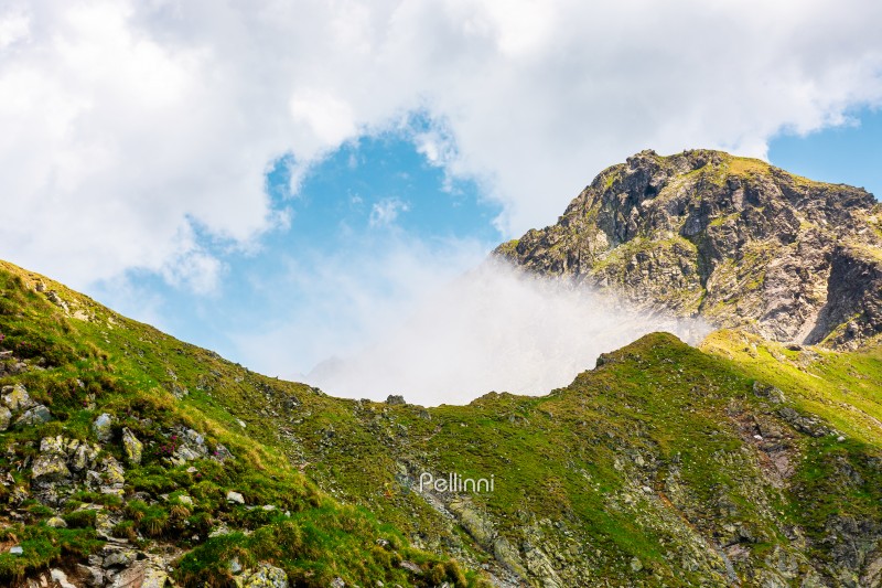 mountain landscape with steep rocky slopes. romania travel backg mountain landscape with steep rocky slopes. romania travel background. clouds on a blue sky above fagaras mountain ridge. stunning weather in summer