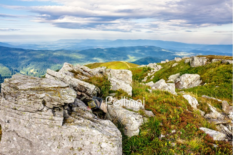 mountain landscape. stones in the grass on the hillside going into the distance under a blue sky