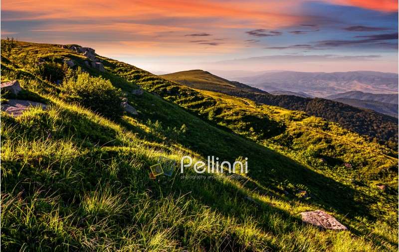 mountain ridge with peak behind the hillside. beautiful summer background at sunset with red sky