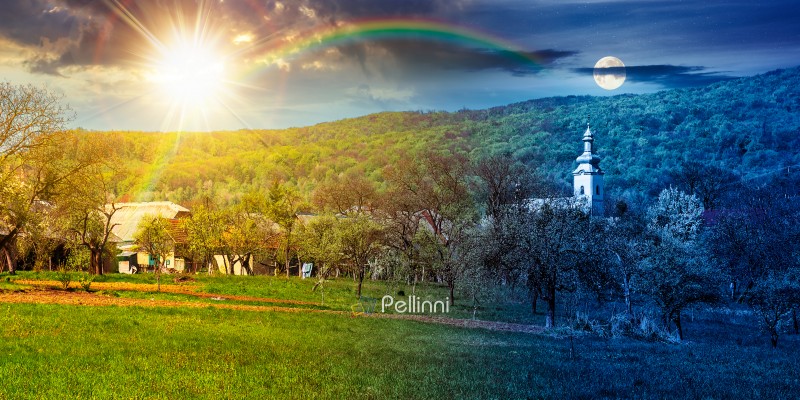 mountainous countryside landscape in spring. day meet night. sun mountainous countryside landscape in spring. day meet night. sun and moon over wonderful weather with cloudy sky. rural orchard in the outskirts of the village. church in the background