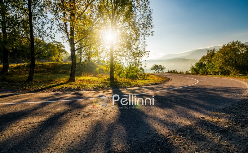 mountainous countryside road at sunrise. beautiful bright weather in early autumn