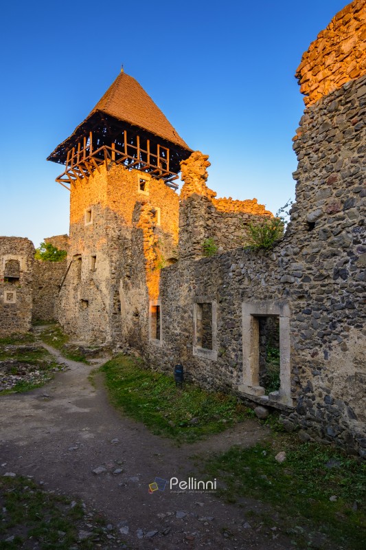 nevytske, ukraine - 19 may, 2018: castle with tower and stone wall at sunset. medieval fortress architecture of ukraine. travel destination and heritage site of transcarpathia