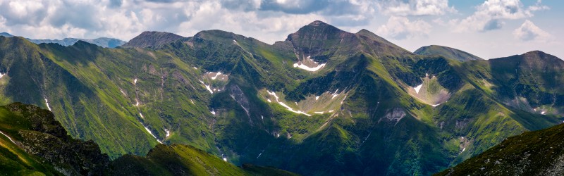 panorama of Fagaras mountain ridge. beautiful landscape with rocky cliffs and grassy slopes in summertime