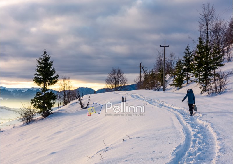 person go through snowy hillside. beautiful scenery of mountainous countryside in winter