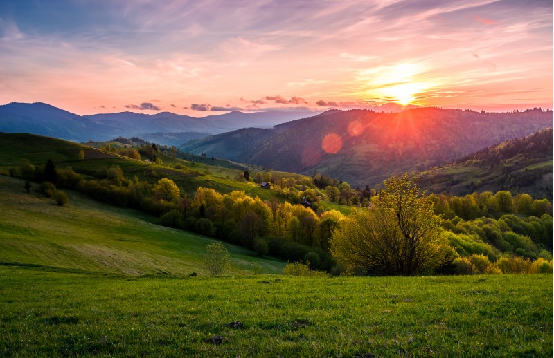 pink sunset over the mountains in springtime. gorgeous Carpathian countryside. beautiful rural scene with agricultural fields on rolling hills