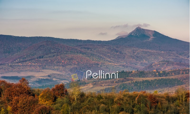 ridge with high peak above hills with forest. lovely mountainous background in late autumn