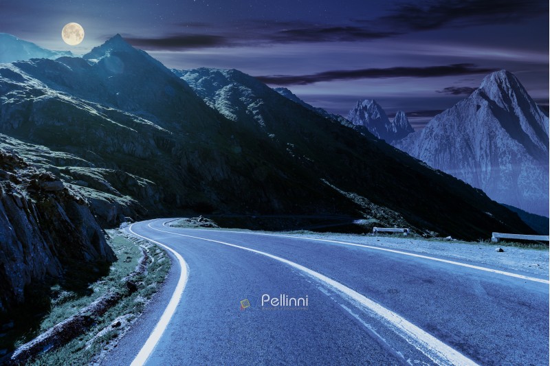 road in mountains with rocky ridge in the distance at night in full moon light. composite image. travel by car concept