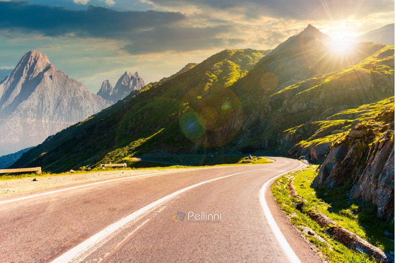 road in mountains with rocky ridge in the distance at sunset. composite image. travel by car concept