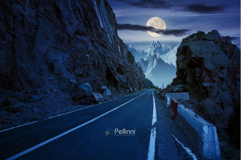 road in to the high mountains between rocky cliff at night in full moon light. composite image of dangerous path to the dreams. 