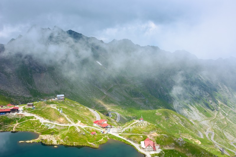 romania travel landscape with road pass. green valley of fagaras mountains. dramatic scenery of transylvania. beautiful view above alpine lake balea in summer. scenic landmark of europe