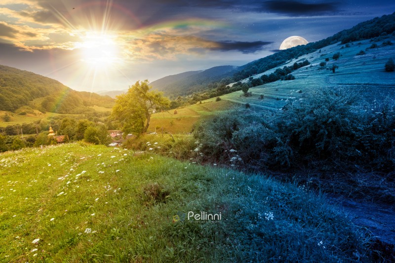 rural landscape with field on a hill in summer. day and night time change concept. countryside with meadow on mountain with sun and moon at twilight. dark scene near village with dirt road and church under the rainbow