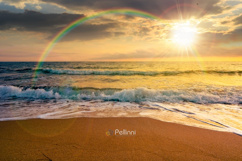 sand beach at the sea for summer vacation concept. beautiful sunset at perfect coast with calm waves and clouds on sky in evening light. scenic landscape for timeless nostalgia book cover with rainbow