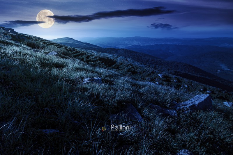 scenic view of alpine landscape in summer at night. picturesque outdoor background with grass on hill and blue sky with clouds. hiking through wonderful carpathian alps in full moon light