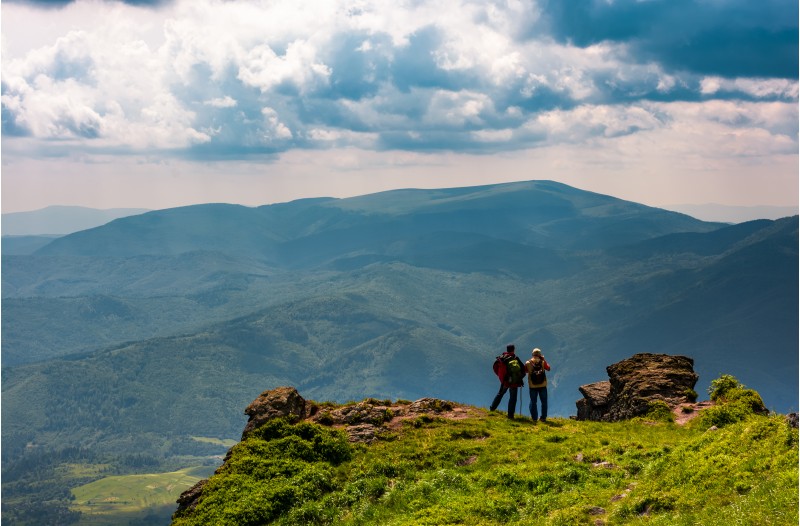 tourists stand on cliff enjoying the view. gorgeous view of magnificent Polonina Runa ridge from the hills of Pikui mountain. Location Ukrainian Carpathians
