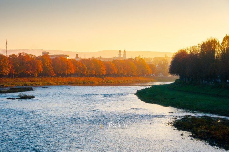 urban landscape with embankment, trees and a river in front. beautiful Uzhhorod town scenery in autumn