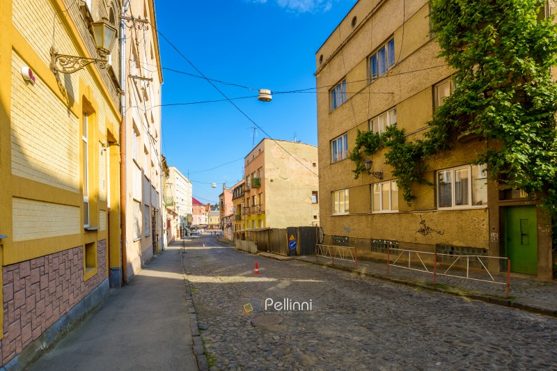 uzhhorod, ukraine - 11 jun 2017: european urban landscape with street of town in morning light. cobblestone path down the hill to koriatovycha square in city center