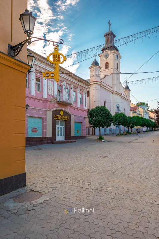 uzhhorod, ukraine - 11 jun 2017: religion landmark on voloshyna uzhhorod, ukraine - 11 jun 2017: religion landmark on voloshyna street. exterior of catholic church of saint george the martyr in the background. picture of uzhhorod city downtown on sunny morning