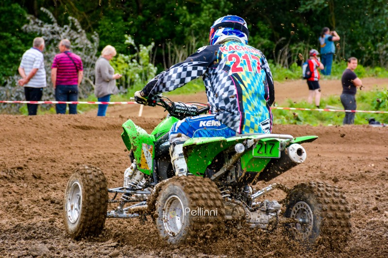 uzhhorod, ukraine - may 21, 2017: ATV rider accelerating on the dirt track. sport competition of green quad wheel vehicle in the mud