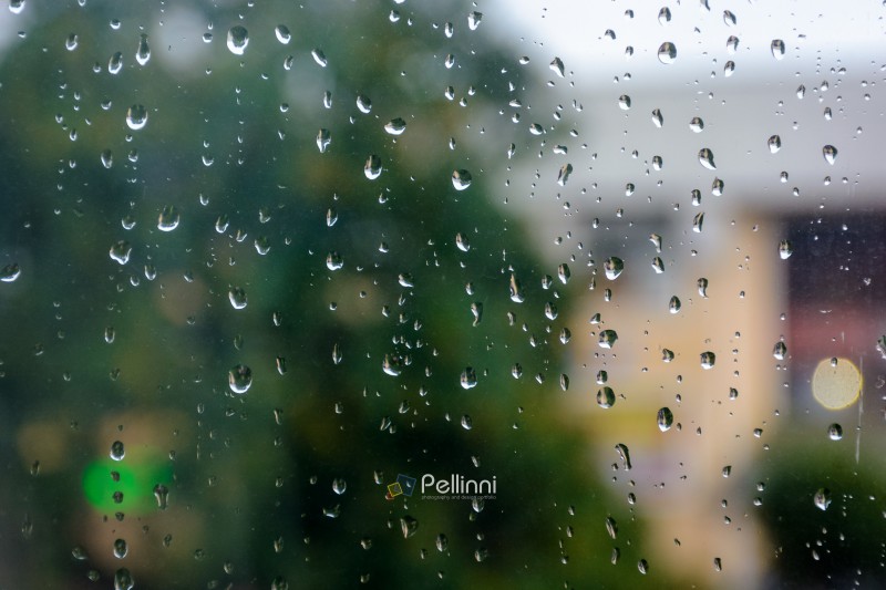 wet window background. rain drop on the glass surface. bad weather concept. urban landscape blurred in the distance
