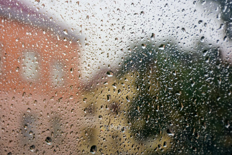 wet window background. rain drop on the glass surface. bad weather concept. urban landscape blurred in the distance