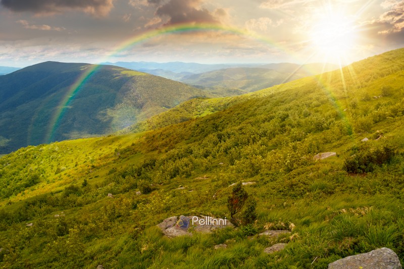 wonderful mountain landscape for travel with green hill in summer at sunset. nature scenery with scenic view in to the distant valley in dappled evening light. hiking through highland under rainbow