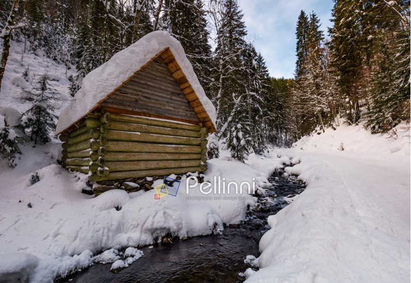 wooden building near the stream in snowy forest. lovely winter scenery, great place for hiking in fine weather
