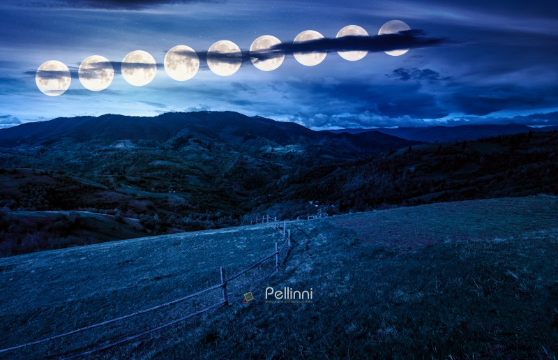 wooden fence on hillside with rural field in mountains at night. beautiful countryside landscape with rolling hills and pasture in spring in full moon light. fake news or conspiracy concepts