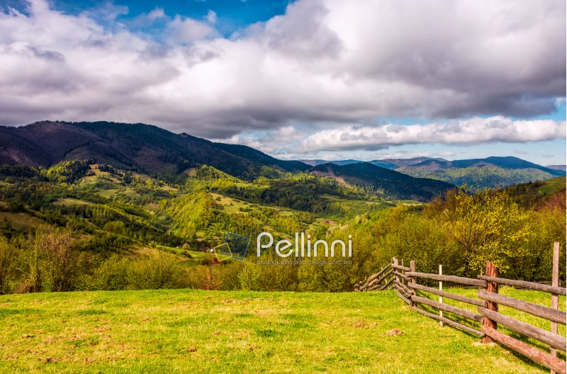 wooden fence on hillside in the rural area in mountains. beautiful countryside landscape.