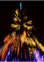 Abstract Christmas lights background at night. Christmas tree blurred with zoom effect 